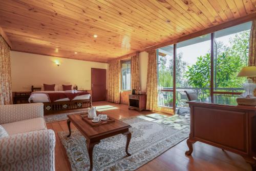 a living room with a bed and a table at The Water Willow By Vanavya in Manāli