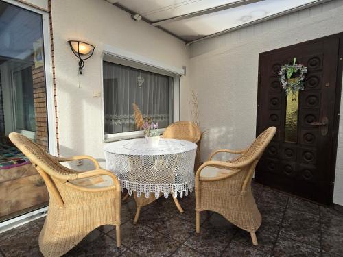 a table and chairs on a patio with a table and a window at Ferienhaus Alla, Neeberg/Usedom in Neeberg