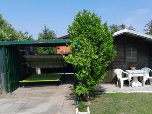a pergola with a bench and a table at Ferienhaus Alla, Neeberg/Usedom in Neeberg