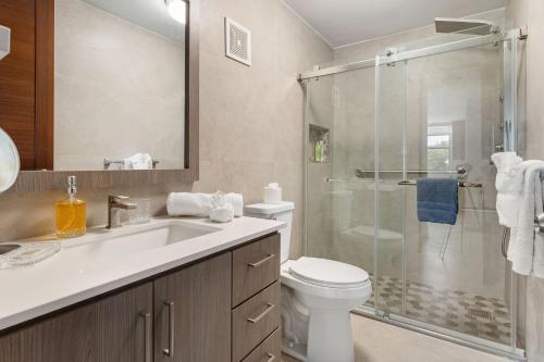 a bathroom with a shower and a toilet and a sink at Costa Ensenada Penthouse 505 across the street from Balneario beach in Rincon
