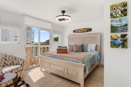 a bedroom with a bed and a balcony at Costa Ensenada Penthouse 505 across the street from Balneario beach in Rincon