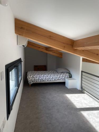 a small room with a bed and a window at Maison en Provence avec terrasse privée - Fibre TV in Lambesc