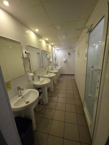 a bathroom with four sinks and a row of mirrors at The Hostel in Kyiv