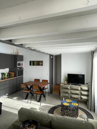 a living room with a table and a kitchen at Maison en Provence avec terrasse privée - Fibre TV in Lambesc