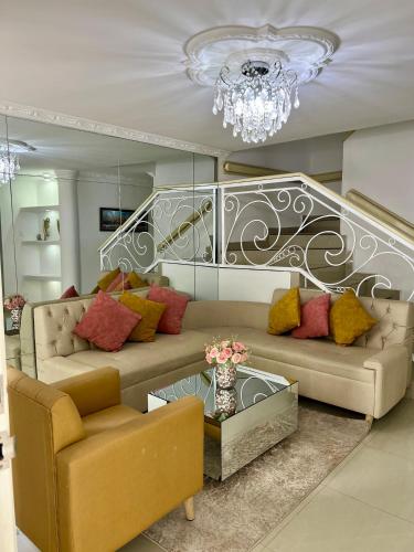 a living room with two couches and a chandelier at Casa full Confort en el corazón de valledupar in Valledupar