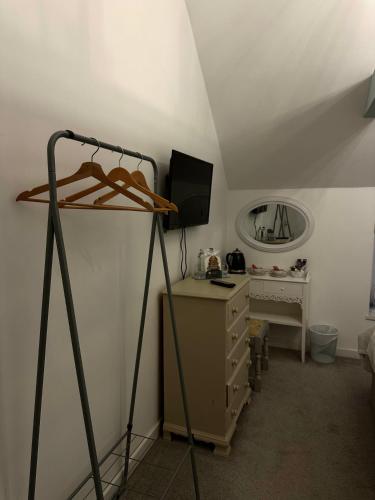 a room with a bed and a dresser with a mirror at The Golden Mile Country Inn in Ewenny