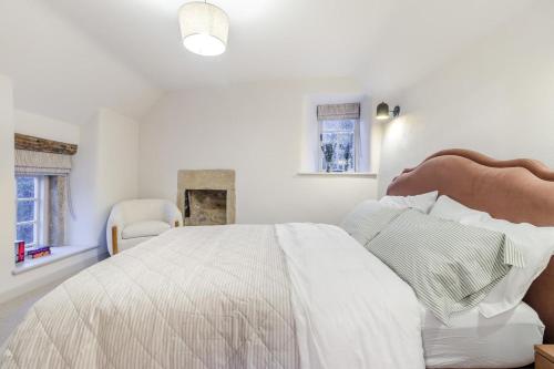 een witte slaapkamer met een groot bed en een stoel bij 2 Bed in Ashover oc-c33546 in Ashover