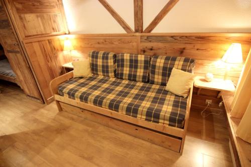 un canapé dans une pièce avec une table et une lampe dans l'établissement Dôme de Polset Appartements VTI, à Val Thorens