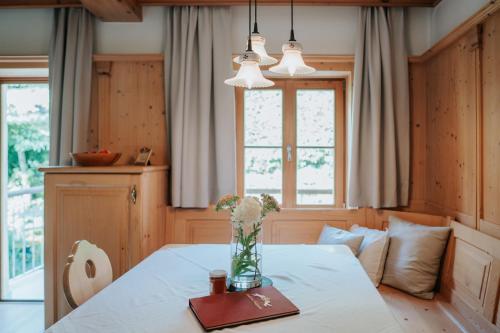 a dining room with a table with a vase of flowers on it at Ansitz Gurtenhof in Tesimo