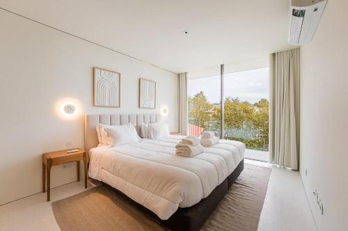 ein Schlafzimmer mit einem großen Bett mit einem großen Fenster in der Unterkunft GuestReady - DPV Residences in Porto