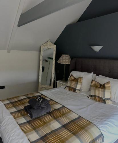 a bedroom with a large bed with a mirror at The Golden Mile Country Inn in Ewenny
