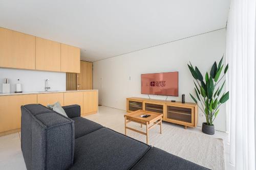 ein Wohnzimmer mit Sofa und Fernseher in der Unterkunft GuestReady - DPV Residences in Porto