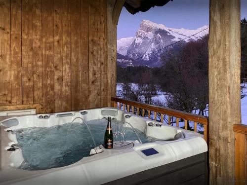 a bath tub in a room with a mountain view at Chalet Trumont - OVO Network in Morillon
