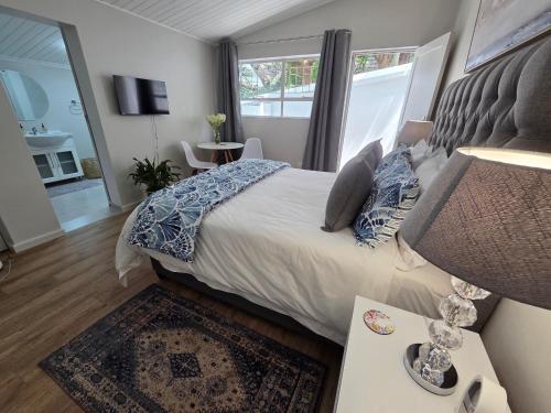 Un dormitorio con una cama y una mesa con una lámpara. en SleepINN at Dumont, en Paarl