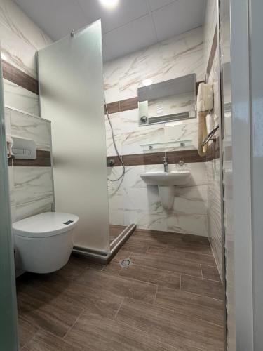a bathroom with a toilet and a sink at Brani Family Hotel in Ruse