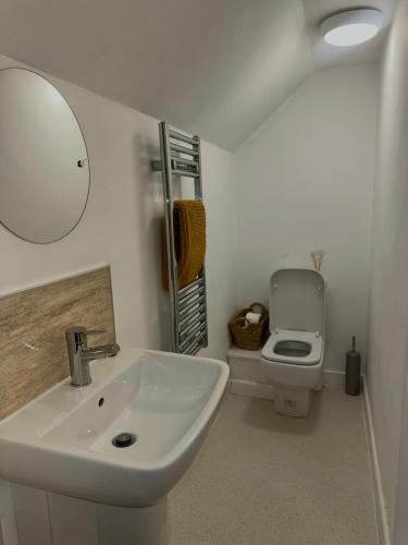 a white bathroom with a sink and a toilet at The Golden Mile Country Inn in Ewenny