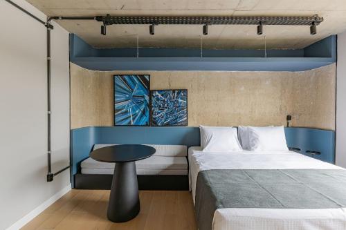 a bedroom with two beds and a table at Moinho Moradia in Juiz de Fora