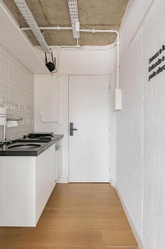 a white kitchen with a door in a room at Moinho Moradia in Juiz de Fora