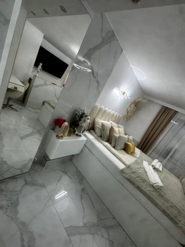 a white bathroom with a marble wall at GOLD apartment in Święta Katarzyna