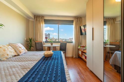 a bedroom with a bed and a view of a city at Skyline Moinhos de Vento in Porto Alegre
