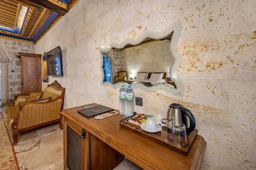 a table with a mirror on a wall with a coffee maker at Cappadocia Secret Hill Cave Suites in Goreme