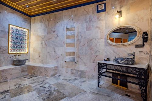 a bathroom with a sink and a mirror at Cappadocia Secret Hill Cave Suites in Goreme