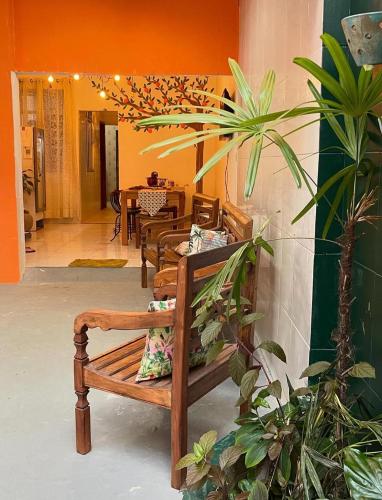a wooden bench sitting in a room with a table at Casa Laranja Hostel in Niterói