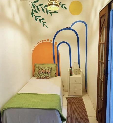 a bedroom with a bed with blue and green accents at Casa Laranja Hostel in Niterói