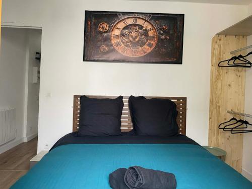 a bedroom with a bed with a clock on the wall at T2 COCOON Centre ville in Marmande