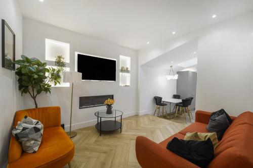 a living room with a couch and a tv at Stylish Kentish Town HomePrivate Garden Jacuzzi in London