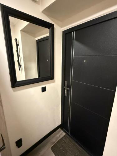 a bathroom with a black door and a mirror at Apartament for Guest in Jelgava