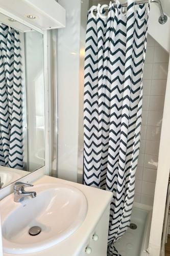 a bathroom with a sink and a shower curtain at Résidence du Parad'Ice in Dinard