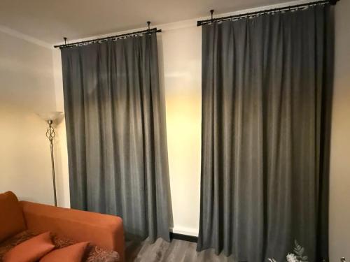 a living room with gray curtains and a couch at Apartament for Guest in Jelgava