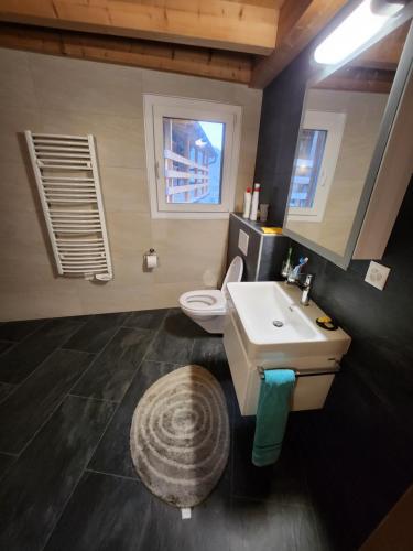 Chalet en montagne في Sembrancher: حمام مع حوض غسيل أبيض ومرحاض