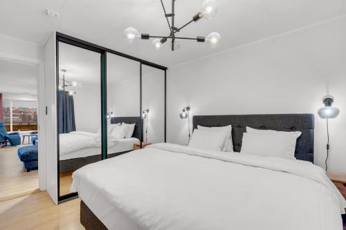 a bedroom with a large white bed and a mirror at Apartment with view of the city in Hjorten