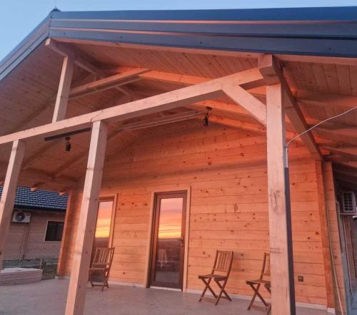 due sedie sul portico di una casa di legno di Kozara Panoramic Resort a Bosanska Gradiška