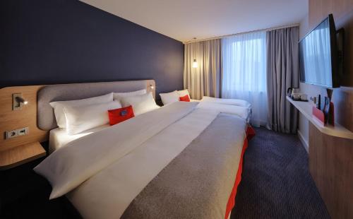 a large white bed in a hotel room at Holiday Inn Express Dortmund by IHG in Dortmund