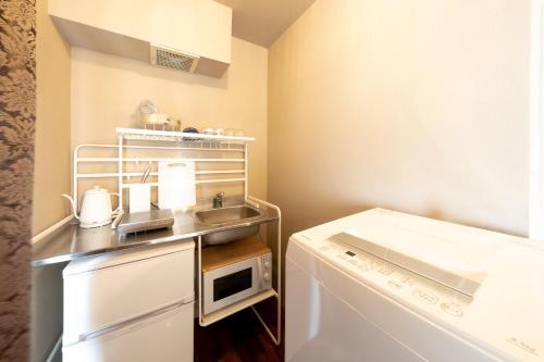 a small kitchen with a sink and a dishwasher at Meijo Lemon Stay in Nagoya
