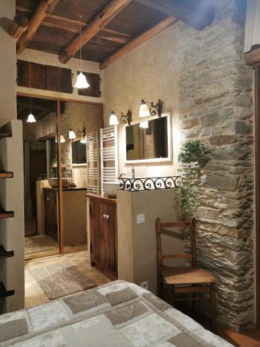 a bedroom with a bed and a stone wall at Gite rustique de charme chez Santa é Pasquà in San-Martino-di-Lota