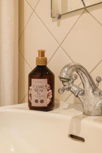 a bottle of soap sitting on a bathroom sink at Flora's Palace - The Hague Scheveningen in The Hague