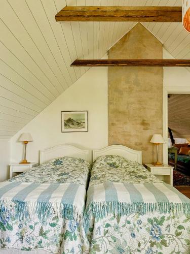 a bedroom with a bed and two lamps on tables at Traditional Red House By The Lake In Småland in Åby