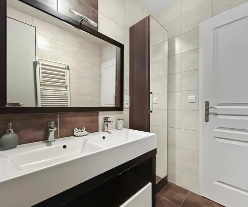 une salle de bains avec un lavabo blanc et un miroir dans l'établissement Maison lumineuse avec terrasse en plein centre, à Angoulême