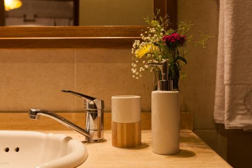 a vase of flowers sitting on a counter next to a sink at Kale Konak Cappadocia in Uchisar