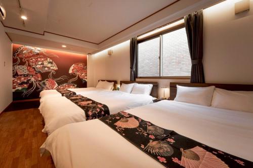 een hotelkamer met 3 bedden en een raam bij The Kabuki-do Inn Haneda in Tokyo