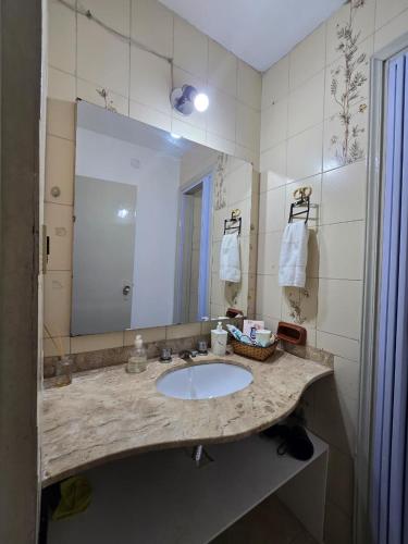 a bathroom with a sink and a large mirror at Esquina Mburucuya in Asunción