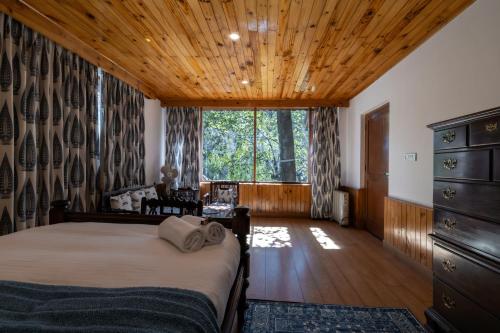 a bedroom with a bed and a large window at The Water Willow By Vanavya in Manāli