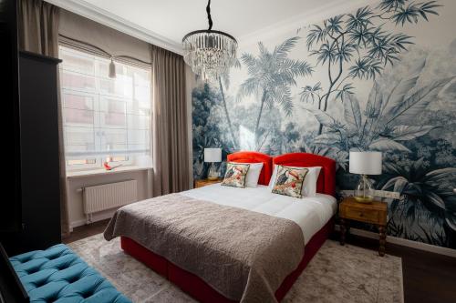 a bedroom with a large bed with a tropical wallpaper at Piotrkowska 89 Residence in Łódź