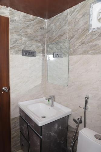 a bathroom with a sink and a mirror and a toilet at Tiger Woods in Jamania