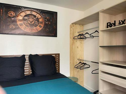 a bedroom with a bed and a clock on the wall at T2 COCOON Centre ville in Marmande