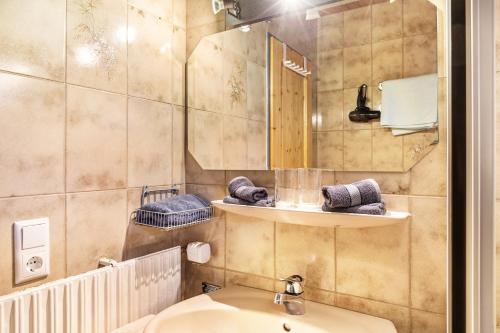 een badkamer met een wastafel en een spiegel bij Ferienwohnung Höllental in Grainau